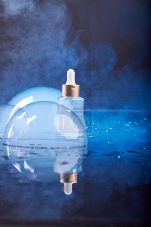 Foto de Botella vertical de perfume con burbuja y vapor de vapor. Colores azul y negro. - Imagen libre de derechos