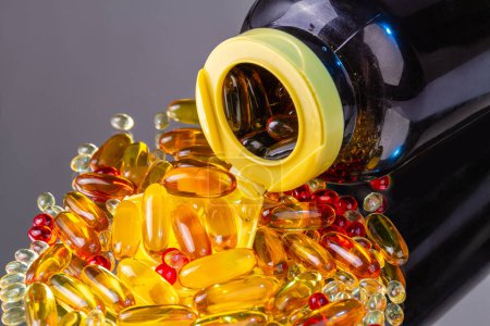 Photo for Close up overturned bottle with pile of vitamin pills. Omega vitamins capsules. - Royalty Free Image