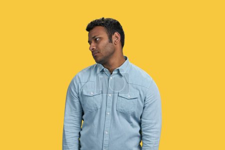 Téléchargez les photos : Beau jeune Indien avec une expression triste. brun guy avec downcast émotion sur jaune fond. - en image libre de droit
