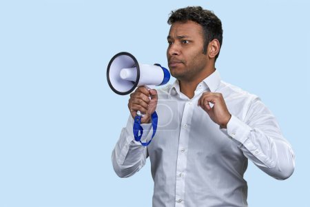Photo for Indian man in white shirt holding a megaphone. Announcing discounts sale. Isolated on blue background. - Royalty Free Image