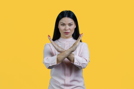 Téléchargez les photos : Jeune femme asiatique geste arrêter en croisant les bras. Isolé sur fond jaune. - en image libre de droit