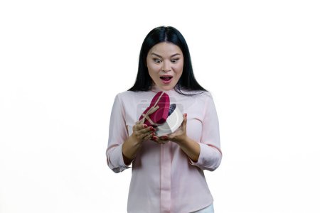 Téléchargez les photos : Choquée et surprise femme asiatique ouvre une boîte-cadeau en forme de coeur. Saint Valentin ou anniversaire. Isolé sur fond blanc. - en image libre de droit