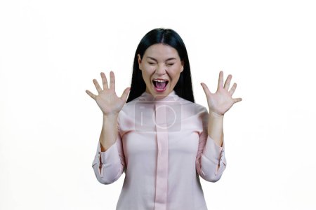 Photo for Young brunette asian woman is screaming out loud. Korean girl with her hands up. Isolated on white background. - Royalty Free Image