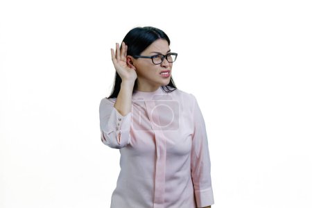 Photo for Young asian businesswoman in glasses is overhearing something bad. Isolated on white background. - Royalty Free Image