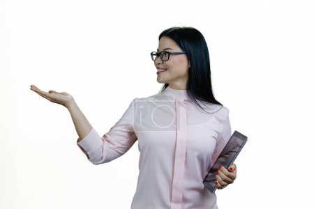 Téléchargez les photos : Jeune femme asiatique avec tablette montrant l'espace de copie avec sa paume. Isolé sur fond blanc. - en image libre de droit