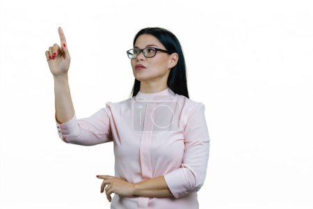 Téléchargez les photos : Femme asiatique intelligente pointant vers l'écran virtuel invisible. Isolé sur fond blanc. - en image libre de droit
