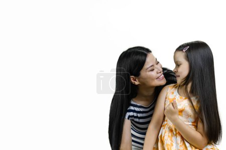 Photo for Smiling asian mom and her little daughter are looking at each others face. Isolated on white. - Royalty Free Image