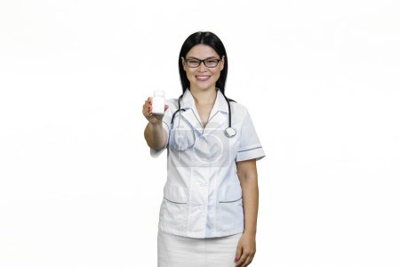 Photo for Portrait of happy asian female doctor giving a white pills bottle. Isolated on white. - Royalty Free Image