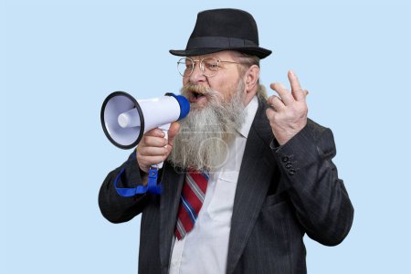 Photo for Portrait of aged senior man giving a speech in megaphone. Isolated on blue pastel background. - Royalty Free Image