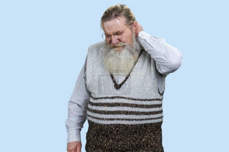 Téléchargez les photos : Portrait d'un homme barbu âgé souffrant de maux de cou. Fond bleu pastel. - en image libre de droit
