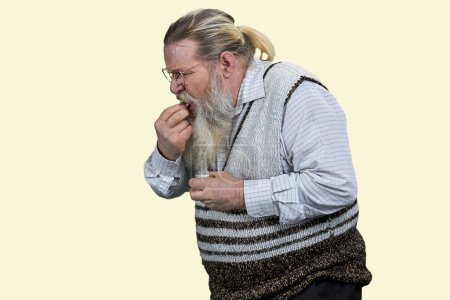 Foto de Hombre barbudo mayor tomando píldora medicinal. Aislado sobre fondo blanco. - Imagen libre de derechos