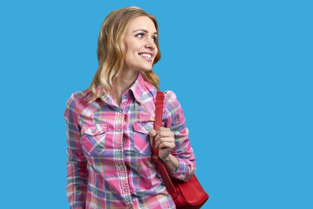 Photo for Portrait of happy young blonde woman with red purse. Isolated on vivid blue background. - Royalty Free Image
