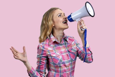 Photo for Portrait of young blonde blue-eyed woman speaking in megaphone. Attractive female with loudspeaker isolated on pink background. - Royalty Free Image
