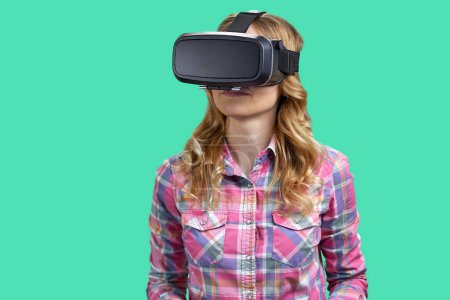 Photo for Portrait of a young woman enjoying vr experience. Isolated on green background. - Royalty Free Image