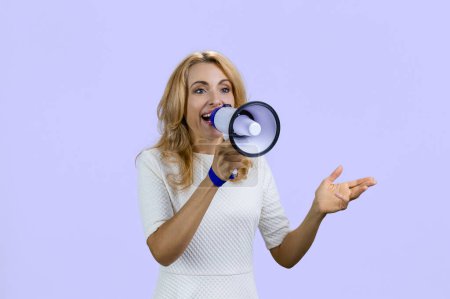 Photo for Happy positive blonde woman giving a speech in megaphone. Isolated on purple. - Royalty Free Image