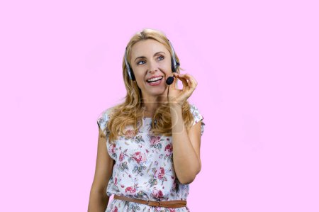 Téléchargez les photos : Portrait de heureuse femme blonde gaie portant un casque. Isolé sur rose. - en image libre de droit