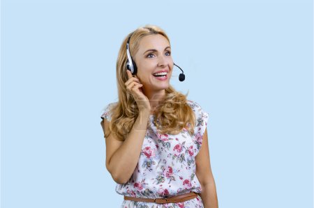 Foto de Retrato de una trabajadora del centro de llamadas feliz usando auriculares. Aislado en azul pálido. - Imagen libre de derechos