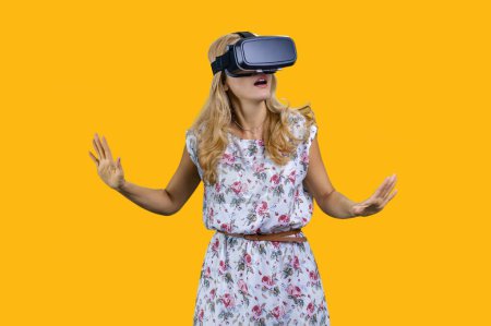 Photo for Happy mature woman wears virtual reality headset. Isolated on yellow. - Royalty Free Image