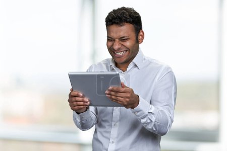 Foto de Feliz hombre de negocios alegre mirando tableta digital pc. Concepto de personas, tecnología y estilo de vida. - Imagen libre de derechos