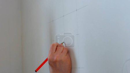 Photo for Builder draws marking on the wall. Worker making measurements. - Royalty Free Image