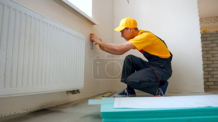 Photo for Worker making apartment renovation by project. Builder making a mark on the plan. - Royalty Free Image