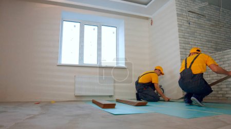 Téléchargez les photos : Isolation thermique du sol de l'appartement. Constructeurs plancher isolé dans une grande maison. - en image libre de droit