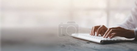 Photo for Person typing on a computer keyboard, businessman is working in a startup company's office, he is typing messages to his colleagues and making financial documents summarizing the meetings. Copy space. - Royalty Free Image