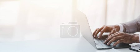 Photo for Person typing on laptop keyboard, businessman working on laptop, he is typing messages to colleagues and making financial information sheet to sum up the meeting. - Royalty Free Image