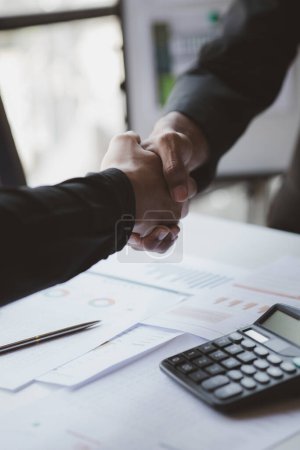 Foto de Business investor group holding hands, Two businessmen are agreeing on business together and shaking hands after a successful negotiation. Handshaking is a Western greeting or congratulation. - Imagen libre de derechos
