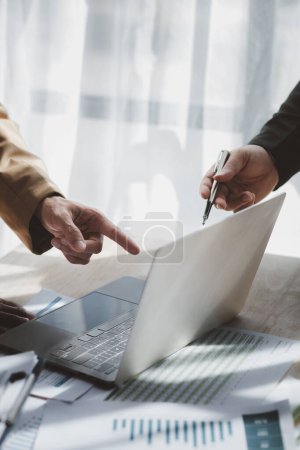 Photo for Businessman is reviewing monthly sales documents for analysis and marketing plans for more sales growth, they are the founders of young companies co-founding startups. Sales management concept. - Royalty Free Image