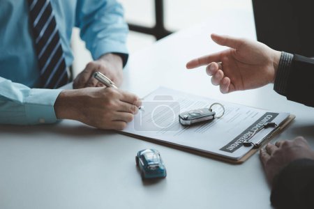 Un vendedor de automóviles está explicando los detalles de compra y los detalles en el contrato de compra de automóviles antes de firmar la aceptación de los términos, el contrato de venta de automóviles a través de un agente. Concepto de comercio de coches.