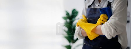 Photo for Asian woman cleaning the office, cleaning worker. Maintain cleanliness within the organization. Office disinfection prevents disease outbreaks and maintains hygiene. - Royalty Free Image