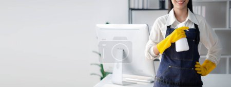 Photo for Asian woman cleaning the office, cleaning worker. Maintain cleanliness within the organization. Office disinfection prevents disease outbreaks and maintains hygiene. - Royalty Free Image