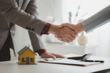 Photo for Housing estate agents shake hands with customers after a deal is completed, explaining and presenting information about homes and purchasing loans. Real estate trading concept. - Royalty Free Image