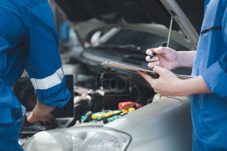 Photo for Two professional car mechanics are helping to inspect a customer's car being brought in for repair, all types of auto specialists, expert car repairs and certified auto repair centers. - Royalty Free Image