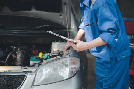 Photo for Professional mechanics are helping to check the customer's repair information that is brought to repair, all kinds of car experts, expert car repairs and standardized car repair centers. - Royalty Free Image