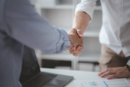 Photo for Business investor group holding hands, Two businessmen are agreeing on business together and shaking hands after a successful negotiation. Handshaking is a Western greeting or congratulation. - Royalty Free Image