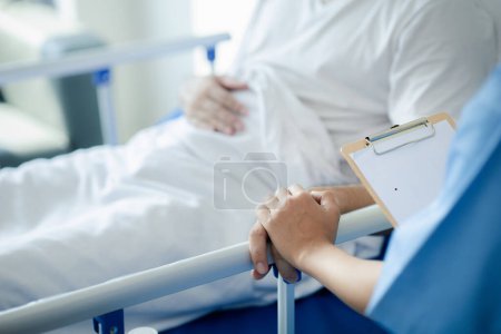 Photo for Patient on an inpatient hospital bed with a doctor examining and asking for information about the symptoms in order to diagnose the correct and appropriate treatment. The concept of medical treatment. - Royalty Free Image