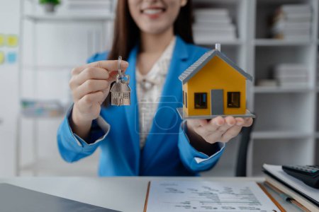 Photo for Housing project sales staff make sales presentations of various types of houses. to customers who visit and explain trading details. Home and real estate salesperson concept. - Royalty Free Image