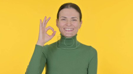 Téléchargez les photos : Young Woman with Ok Sign on Yellow Background - en image libre de droit