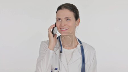 Téléchargez les photos : Jeune femme médecin parlant au téléphone sur fond blanc - en image libre de droit