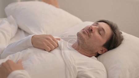 Foto de Hombre adulto maduro cansado acostado en la cama para dormir - Imagen libre de derechos