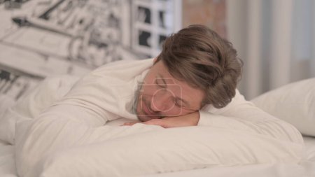 Foto de Hombre adulto maduro durmiendo acostado boca abajo en la cama - Imagen libre de derechos