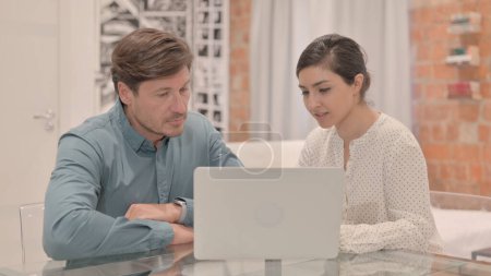 Indian Woman Discussing Work on Laptop with Colleague