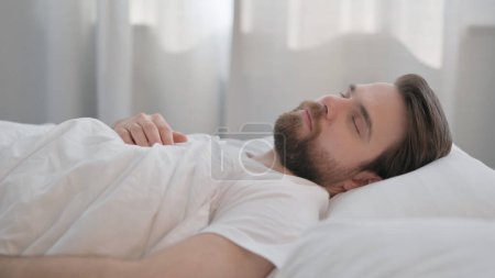 Foto de Vista lateral del hombre adulto joven durmiendo en la cama - Imagen libre de derechos