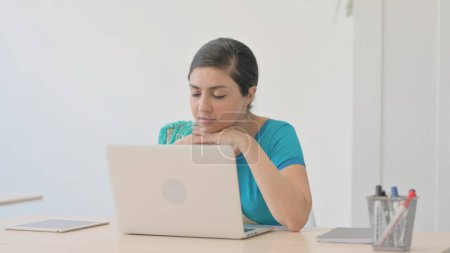 Foto de Mujer india cansada en Sari durmiendo sentada frente a la computadora portátil - Imagen libre de derechos
