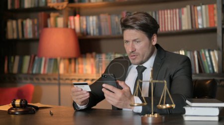 Foto de Abogado masculino molesto por fallo de pago en línea en el teléfono en la oficina - Imagen libre de derechos