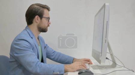 Middle Aged Man Leaving Office after Working on Desktop
