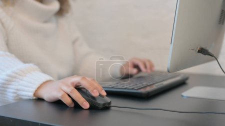Mano femenina usando el ratón de computadora para el trabajo