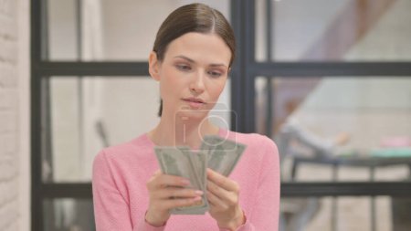 Portrait de jeune femme comptant l'argent
